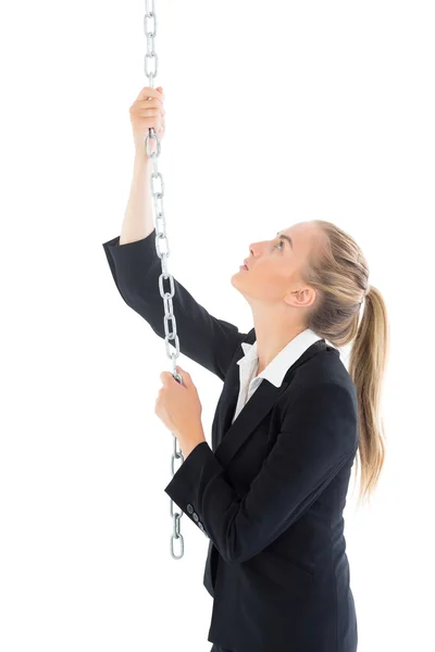 Profile view of ponytailed blonde woman pulling a chain — Stock Photo, Image