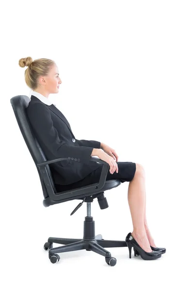 Bir ofis sandalye üzerinde oturan ciddi iş kadını yan görünüm — Stok fotoğraf