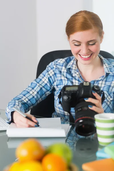 Kameraya bakarak masasına oturan fotoğrafçı gülümseyen — Stok fotoğraf