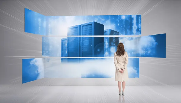 Rear view of businesswoman looking at futuristic server towers — Stock Photo, Image