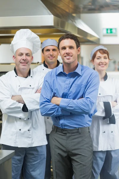 Bonito gerente posando com alguns chefs — Fotografia de Stock