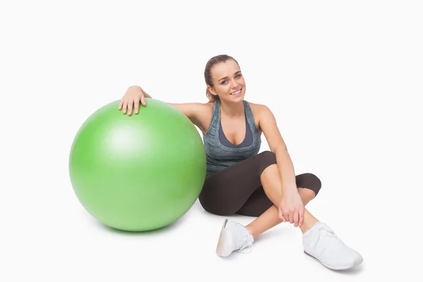 Mulher bonito sentado ao lado de uma bola de fitness — Fotografia de Stock