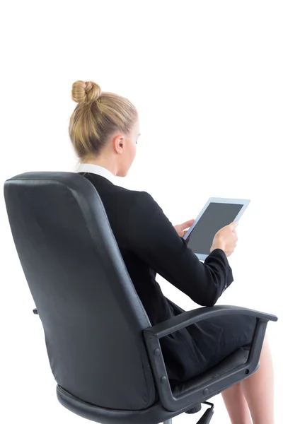 Junge Geschäftsfrau sitzt auf ihrem Bürostuhl und hält ein Tablet in der Hand — Stockfoto