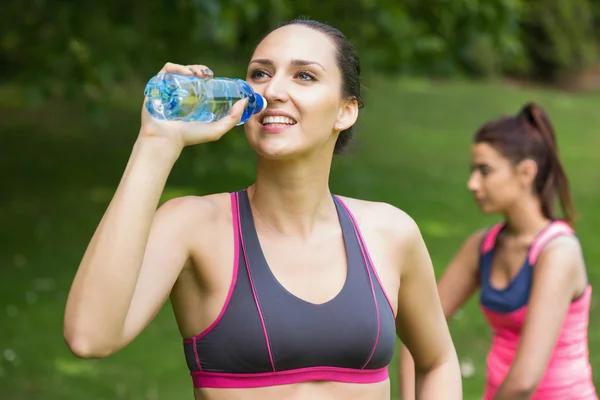 Linda mujer en forma usando ropa deportiva agua potable —  Fotos de Stock