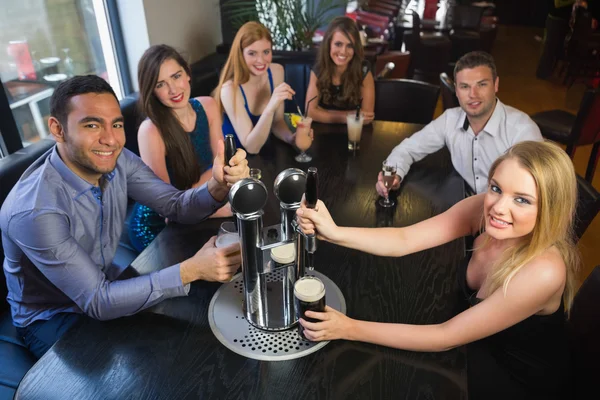 Jóvenes amigos sentados juntos y tomando cerveza en un restaurante —  Fotos de Stock