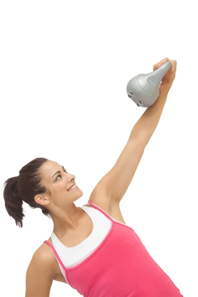 Vrolijke sportieve brunette holding grijs en kettlebell — Stockfoto