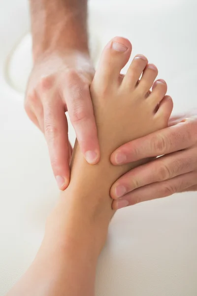 Physiotherapist kneading patients foot — Stock Photo, Image
