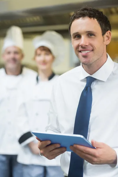 Joven gerente de restaurante sosteniendo su tableta — Foto de Stock