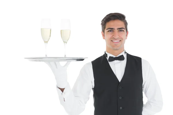 Sorridente attraente tenendo un vassoio con bicchieri di champagne su di esso — Foto Stock