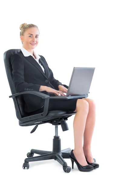 Sorrindo jovem empresária sentada em uma cadeira de escritório — Fotografia de Stock