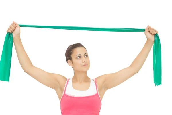 Calm sporty brunette stretching with resistance band — Stock Photo, Image