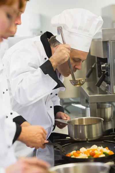 Três chefs trabalhando no fogão — Fotografia de Stock