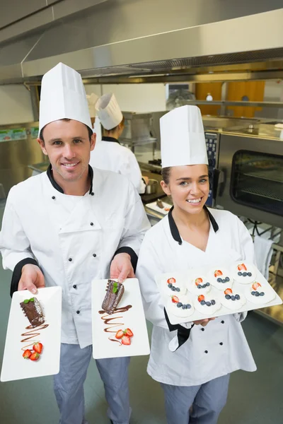 Zwei junge Köche präsentieren Dessertteller — Stockfoto