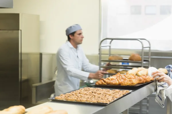 Jovem padeiro trabalhando em uma cozinha — Fotografia de Stock