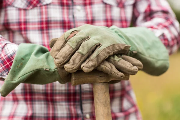 Bonde bär check skjorta lutande på en spade — Stockfoto