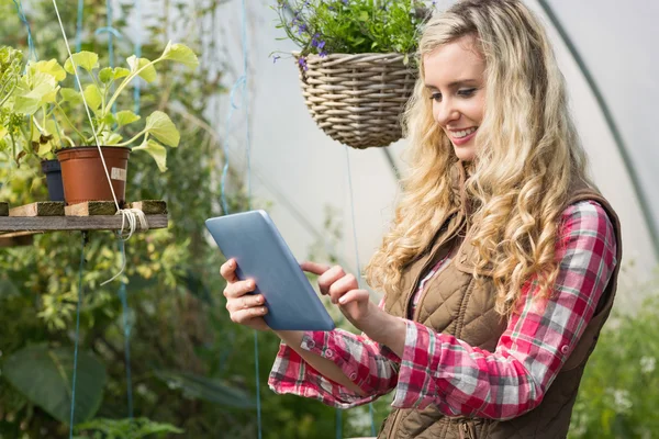 Güzel bir kadın onun tablet yeşil bir evde kullanma — Stok fotoğraf