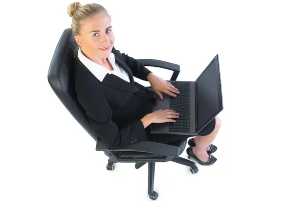 Linda mujer de negocios sentada en su silla de oficina usando su cuaderno — Foto de Stock