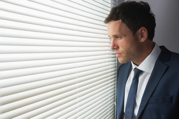 Serious handsome businessman looking out of window — Stock Photo, Image