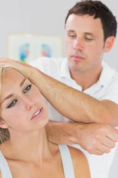 Calm physiotherapist massaging patients neck with elbow — Stock Photo, Image