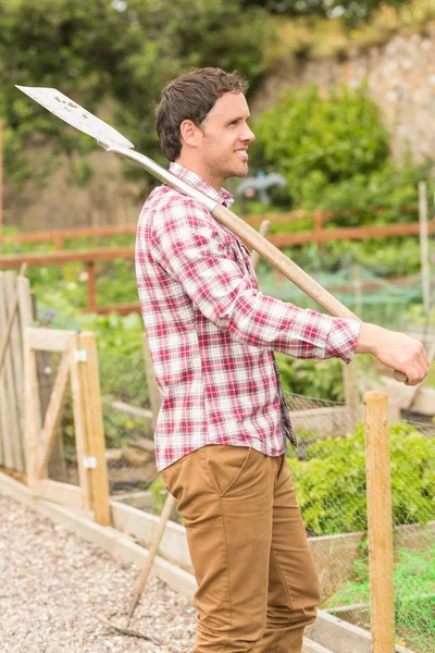 Lächelnder junger Mann posiert mit Schaufel — Stockfoto