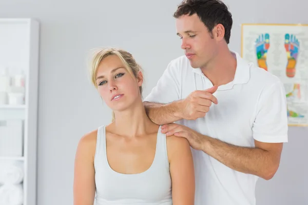 Atractivo fisioterapeuta masajeando pacientes cuello con codo —  Fotos de Stock