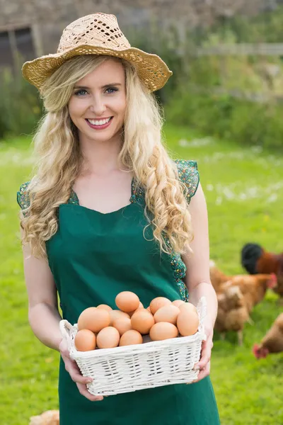Glückliche junge Frau hält einen Korb mit Eiern — Stockfoto