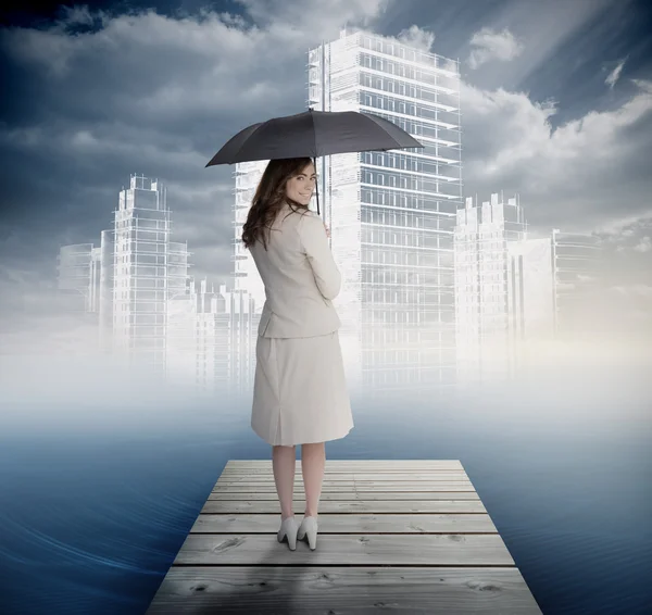 Femme d'affaires souriante debout sur le pont en face de la ville blanche — Photo