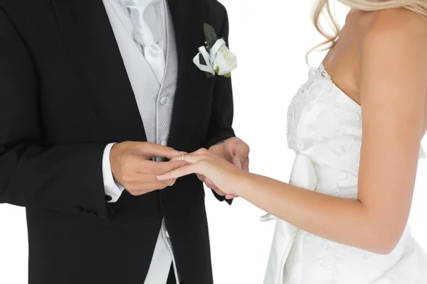 Bridegroom putting the wedding ring on his wifes finger — Stock Photo, Image