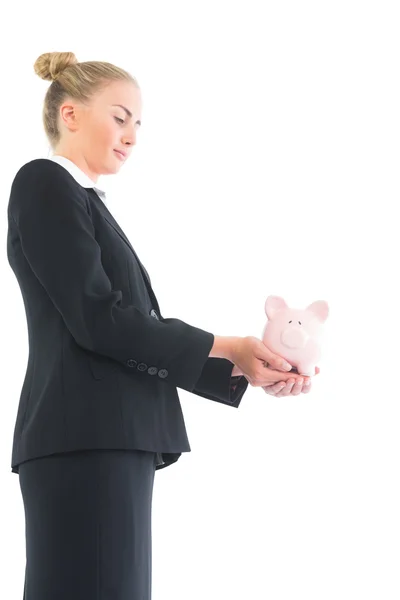 Zijaanzicht van jonge zakenvrouw houden van roze piggy bank — Stockfoto