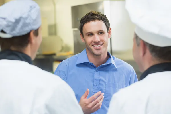 Jovem gerente sorrindo conversando com a equipe — Fotografia de Stock