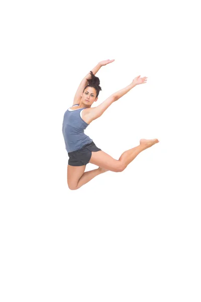 Pretty sporty brunette jumping in the air with arms up — Stock Photo, Image