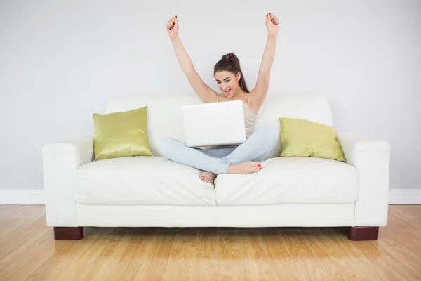 Cheerful young woman making use of her laptop — Stock Photo, Image