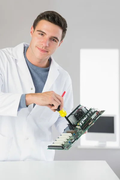 Attractive content computer engineer repairing hardware with screw driver — Stock Photo, Image