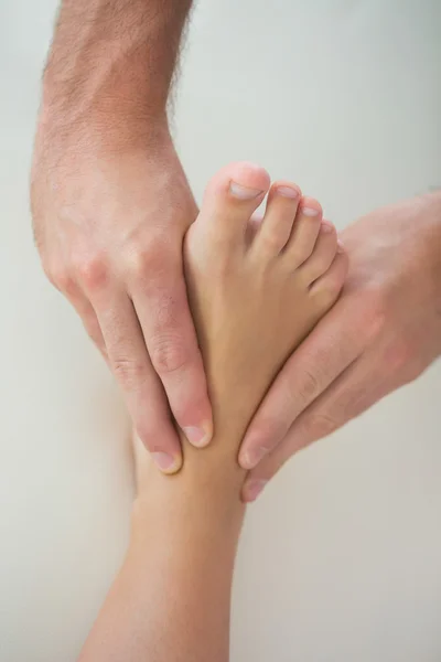 Close up of physiotherapist kneading patients foot — Stock Photo, Image