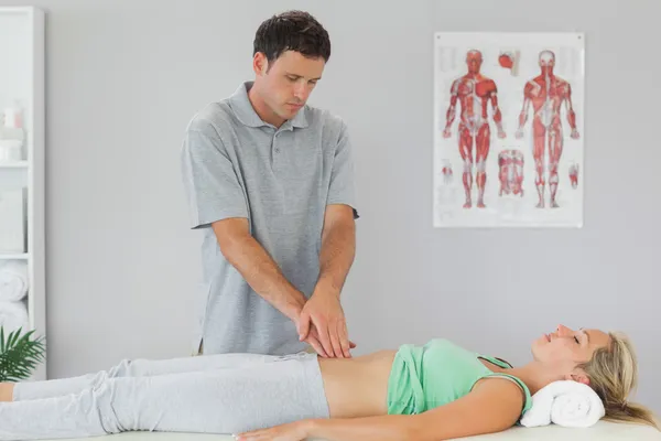 Physiotherapist examining patients pelvis — Stock Photo, Image