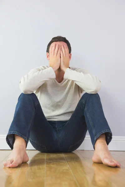 Casual onrustige man die betrekking hebben op zijn gezicht met handen — Stockfoto