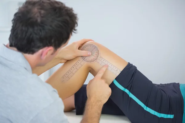 Fisioterapeuta midiendo rodilla con goniómetro —  Fotos de Stock