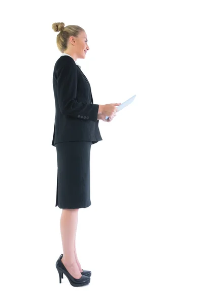 Vista lateral de la joven mujer de negocios elegante sosteniendo su tableta — Foto de Stock