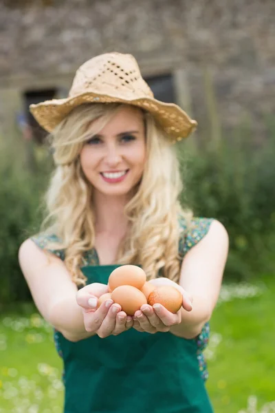 Jeune femme blonde montrant des œufs — Photo