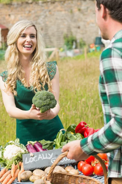 Fiatal női farmer eladási szerves brokkoli — Stock Fotó