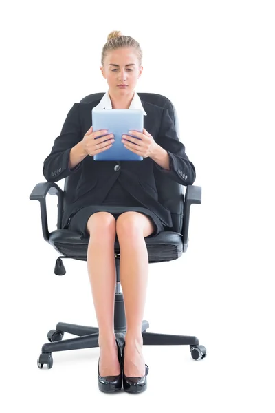 Vista frontal de una mujer de negocios elegante concentrada usando su tableta —  Fotos de Stock