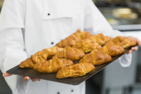 Baker apresentando alguns croissants — Fotografia de Stock