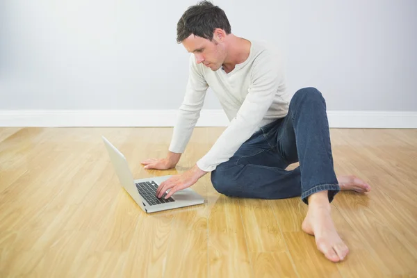 Casual kalme man zit op de vloer met behulp van laptop — Stockfoto