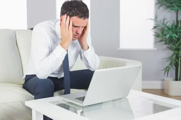 Aufgebrachter gutaussehender Geschäftsmann arbeitet am Laptop — Stockfoto