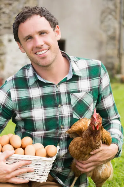 Giovane che tiene il suo pollo e cesto di uova — Foto Stock