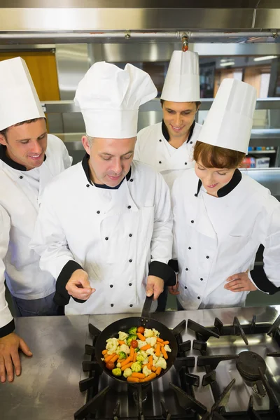 Experienced head chef explaining something to his colleagues — Stock Photo, Image
