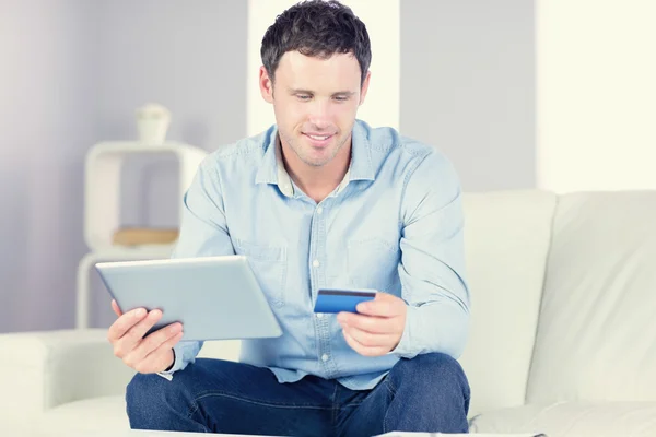 Uśmiechnięty mężczyzna dorywczo za pomocą tabletu i karty kredytowej — Zdjęcie stockowe