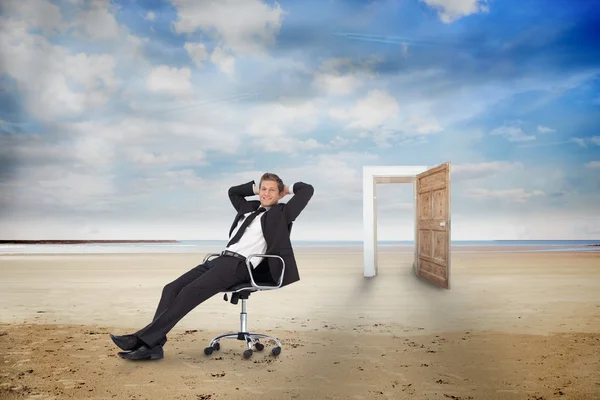 Businessman on swivel chair on the beach — Stock Photo, Image