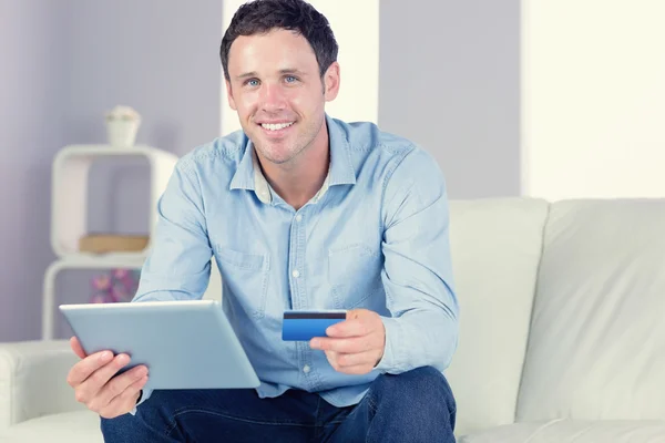 Sonriente hombre casual sosteniendo tableta y tarjeta de crédito — Foto de Stock