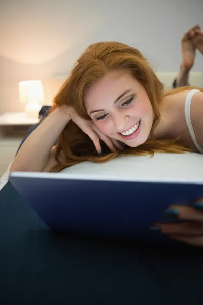 Atrakcyjny rudy za pomocą cyfrowego tabletu leżąc na łóżku — Zdjęcie stockowe